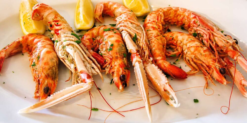 Plateau de gambas et langoustines fraîches accompagnées de quartiers de citron, servi au restaurant El Faro dans le quartier des Pâquis à Genève